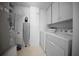 Well-lit laundry room with washer, dryer, and storage cabinets at 7682 St Andrews Blvd, Weeki Wachee, FL 34613