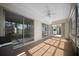 Enclosed sunroom featuring tile floors, a ceiling fan, and sliding glass doors for abundant natural light at 7682 St Andrews Blvd, Weeki Wachee, FL 34613