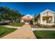 Exterior view of the Millpond Estates clubhouse entrance with a covered walkway and manicured landscaping at 7807 Hardwick Dr # 123, New Port Richey, FL 34653
