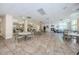 Spacious common area with tile flooring, fireplace, tables, and chairs in the Millpond Estates clubhouse at 7807 Hardwick Dr # 123, New Port Richey, FL 34653