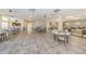 Open common area with tile flooring, tables, and chairs in the Millpond Estates clubhouse at 7807 Hardwick Dr # 123, New Port Richey, FL 34653