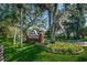 View of the Millpond Estates entrance sign, highlighted by colorful flower beds and mature trees at 7807 Hardwick Dr # 123, New Port Richey, FL 34653