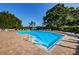 Sparkling community pool surrounded by brick pavers, mature trees and plenty of lounge chairs at 7807 Hardwick Dr # 123, New Port Richey, FL 34653