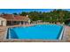 Expansive community pool and surrounding area featuring poolside furniture, and mature tropical landscaping at 7807 Hardwick Dr # 123, New Port Richey, FL 34653