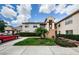 Condo building with a red car in the driveway, lawn and landscaping in front at 7807 Hardwick Dr # 123, New Port Richey, FL 34653