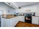 Well-equipped kitchen featuring white cabinets and granite countertops with black appliances at 7807 Hardwick Dr # 123, New Port Richey, FL 34653