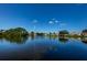 Wide view of the serene pond, showcasing a central fountain and waterfront homes under a clear blue sky at 7807 Hardwick Dr # 123, New Port Richey, FL 34653