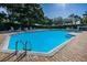 Inviting community pool with crystal-clear water, surrounded by lush greenery, perfect for a refreshing swim at 7807 Hardwick Dr # 123, New Port Richey, FL 34653