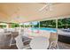 Relaxing poolside patio area with tables and chairs, perfect for enjoying the beautiful pool and community amenities at 7807 Hardwick Dr # 123, New Port Richey, FL 34653