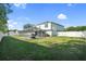 Large, fenced backyard featuring a screened-in pool and green lawn, perfect for outdoor enjoyment at 8388 Maltby Rd, Spring Hill, FL 34606
