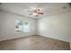Bright bedroom features wood-look flooring, a ceiling fan, and a window with natural light at 8388 Maltby Rd, Spring Hill, FL 34606