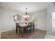 Elegant dining room with stylish light fixture, decorative mirror, and a view of the front yard at 8388 Maltby Rd, Spring Hill, FL 34606