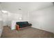 A carpeted living room with a futon sofa against a white wall at 8388 Maltby Rd, Spring Hill, FL 34606