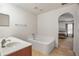 Inviting main bathroom with a soaking tub, tiled floors, and access to the main bedroom at 8388 Maltby Rd, Spring Hill, FL 34606