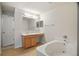 Bright main bathroom with a large mirror, vanity, and a soaking tub at 8388 Maltby Rd, Spring Hill, FL 34606