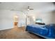 Relaxing main bedroom with plush carpet, ceiling fan, and an archway to the bathroom at 8388 Maltby Rd, Spring Hill, FL 34606