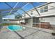 Backyard pool area with patio, hot tub, and screen enclosure at 8388 Maltby Rd, Spring Hill, FL 34606