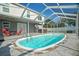 Screened-in backyard pool with a patio and a hot tub, perfect for outdoor enjoyment at 8388 Maltby Rd, Spring Hill, FL 34606