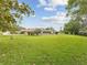 The expansive grassy backyard includes mature trees and lush landscaping at 8393 Delaware Dr, Weeki Wachee, FL 34607