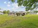A large grassy backyard featuring a screened-in patio area and mature landscaping at 8393 Delaware Dr, Weeki Wachee, FL 34607