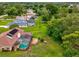 A spacious backyard featuring a screened-in pool, a brown brick patio, solar panels, and lush greenery at 8393 Delaware Dr, Weeki Wachee, FL 34607