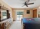 Spacious bedroom with a large dresser, ceiling fan, and sliding glass doors to the pool area at 8393 Delaware Dr, Weeki Wachee, FL 34607