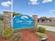 Community sign reading River Country Estates with brick pillars, colorful plants, and a well-maintained landscape at 8393 Delaware Dr, Weeki Wachee, FL 34607