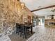 Dining area adjacent to the living room, showcasing a stone wall, modern lighting, and access to the back yard at 8393 Delaware Dr, Weeki Wachee, FL 34607