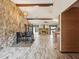 Open-concept dining area with a stone accent wall, wood beam, and an adjacent living space with fireplace at 8393 Delaware Dr, Weeki Wachee, FL 34607
