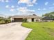 Exterior of the house, showcasing the garage, landscaped yard, and screened-in patio at 8393 Delaware Dr, Weeki Wachee, FL 34607