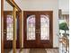 Elegant foyer with decorative doors, a mirrored closet, and views of the staircase and outdoor scenery at 8393 Delaware Dr, Weeki Wachee, FL 34607