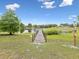 Scenic lake view featuring a wooden dock and lush green surroundings under a beautiful blue sky at 8393 Delaware Dr, Weeki Wachee, FL 34607