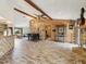 Spacious living room featuring wood-look floors, vaulted ceilings with wood beams, stone accent wall and fireplace at 8393 Delaware Dr, Weeki Wachee, FL 34607