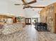Open concept living area with wood-look flooring, stone accent wall, bar area, and dining space at 8393 Delaware Dr, Weeki Wachee, FL 34607