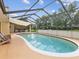 Sparkling private pool is enclosed with a screened lanai and has a nearby patio at 8393 Delaware Dr, Weeki Wachee, FL 34607