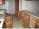 Outdated kitchen featuring wooden cabinets and a white refrigerator, needs renovation at 8640 Lake Isle Dr # 188, Temple Terrace, FL 33637