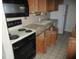 Vintage kitchen with wooden cabinets, standard appliances, and an electric range, ready for renovation at 8640 Lake Isle Dr # 188, Temple Terrace, FL 33637