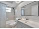 Bright bathroom featuring a shower and tub combination with a patterned shower curtain, updated vanity, and a skylight at 9005 Lido Ln, Port Richey, FL 34668