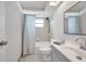 Bright bathroom featuring a shower and tub combination with a patterned shower curtain, updated vanity, and a skylight at 9005 Lido Ln, Port Richey, FL 34668