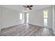 Spacious bedroom with ample natural light, wood-look flooring, a ceiling fan, and an en suite bathroom at 9005 Lido Ln, Port Richey, FL 34668