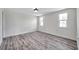 Well-lit bedroom with wood-look flooring, neutral walls, and two windows allowing ample natural light at 9005 Lido Ln, Port Richey, FL 34668