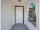 Close-up of a white front door with black trim, surrounded by textured walls at 9005 Lido Ln, Port Richey, FL 34668