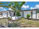 Exterior view of single-story home with white facade, black trim, and a well-manicured lawn at 9005 Lido Ln, Port Richey, FL 34668