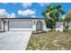 Charming single-story home with white exterior, two-car garage, and well-maintained landscaping at 9005 Lido Ln, Port Richey, FL 34668