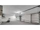 Bright garage with a roll-up door, utility sink, and potential for storage or workspace at 9005 Lido Ln, Port Richey, FL 34668