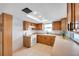 Bright kitchen features oak cabinets, tiled countertops, white appliances and a large window at 9005 Lido Ln, Port Richey, FL 34668
