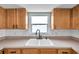 A close up view of the kitchen sink featuring modern faucet and tiled backsplash with a view to the outdoors at 9005 Lido Ln, Port Richey, FL 34668