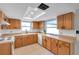 Cozy kitchen with tile floors, wood cabinets, white backsplash, and ample counter space at 9005 Lido Ln, Port Richey, FL 34668
