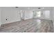 Bright open-concept living room is enhanced by modern gray floors and white walls at 9005 Lido Ln, Port Richey, FL 34668