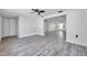 A spacious living room with modern, gray wood floors and a ceiling fan with connecting rooms at 9005 Lido Ln, Port Richey, FL 34668